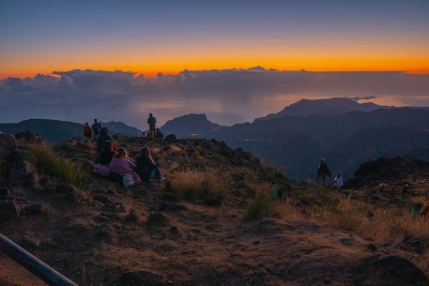 a person standing in front of a sunset